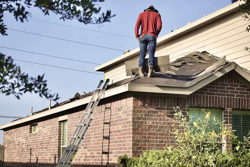 Professional roofer working on a residential roof in Mena